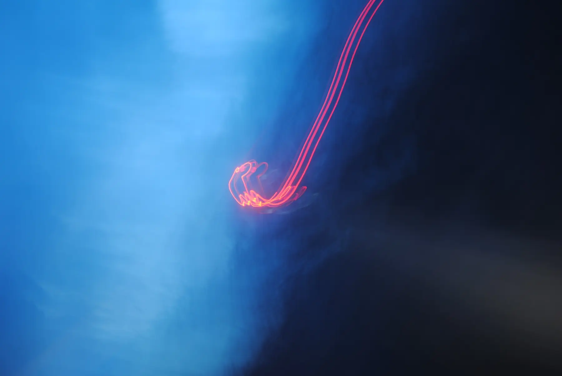 Red light trail across a deep blue frame