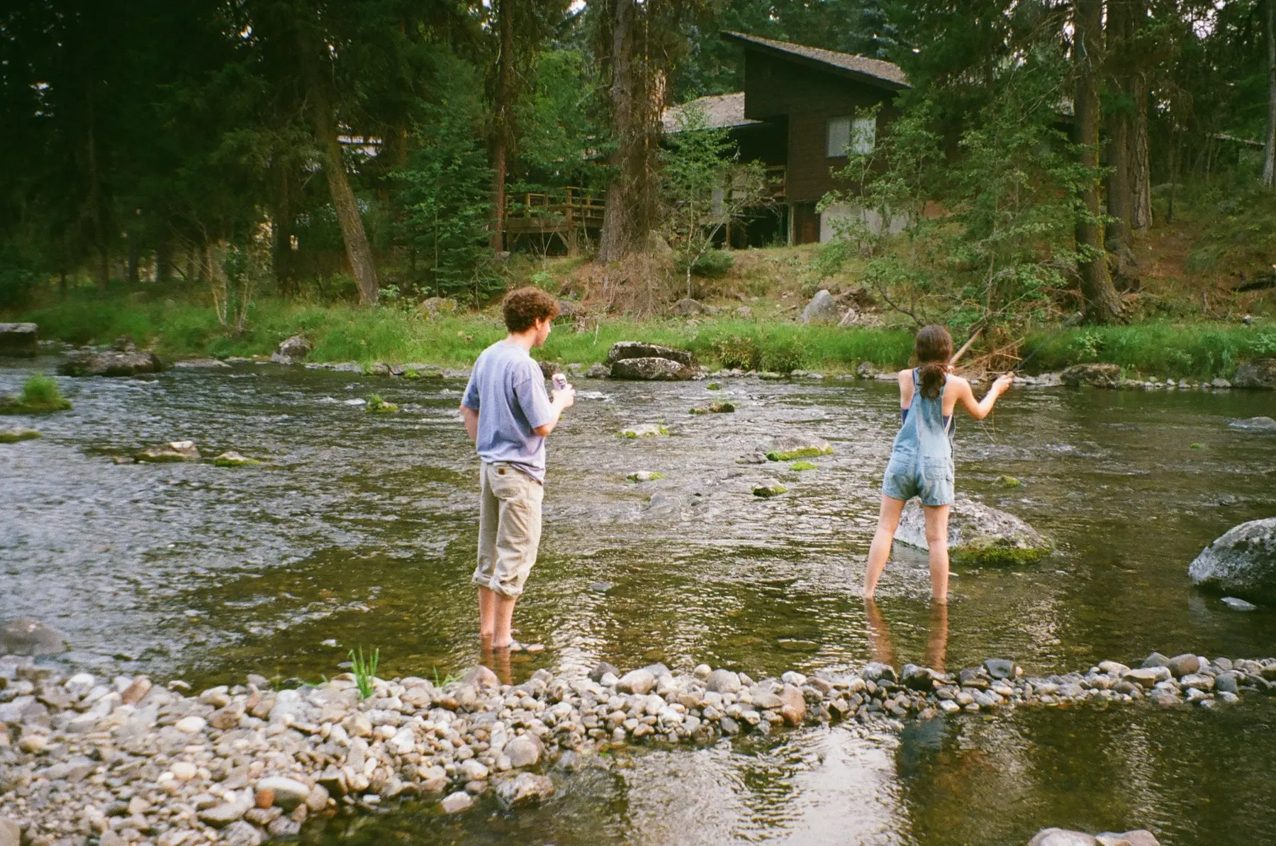 Two people standing in a shallow river