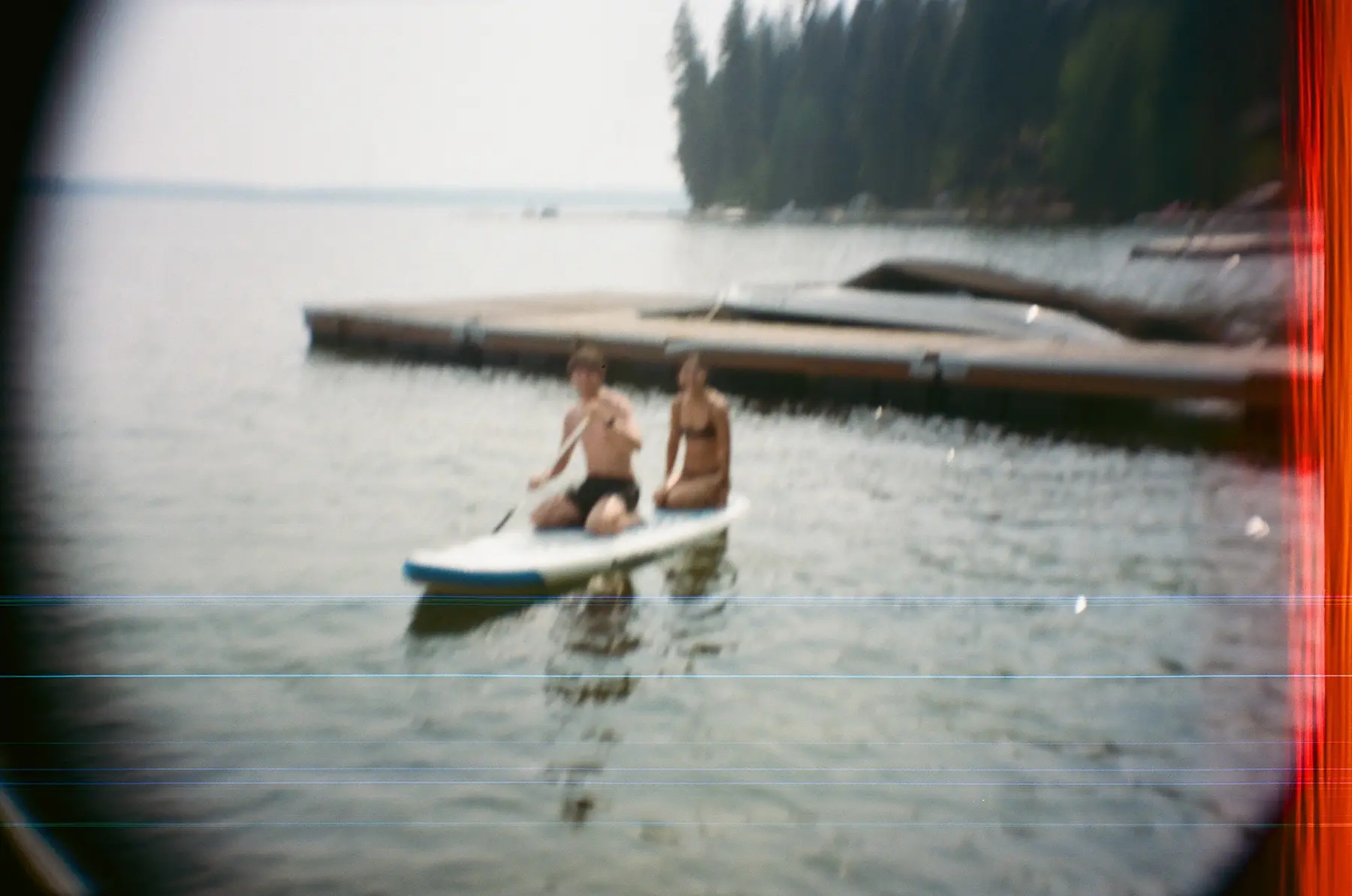 Two people on a paddleboard, photographed through a light leak