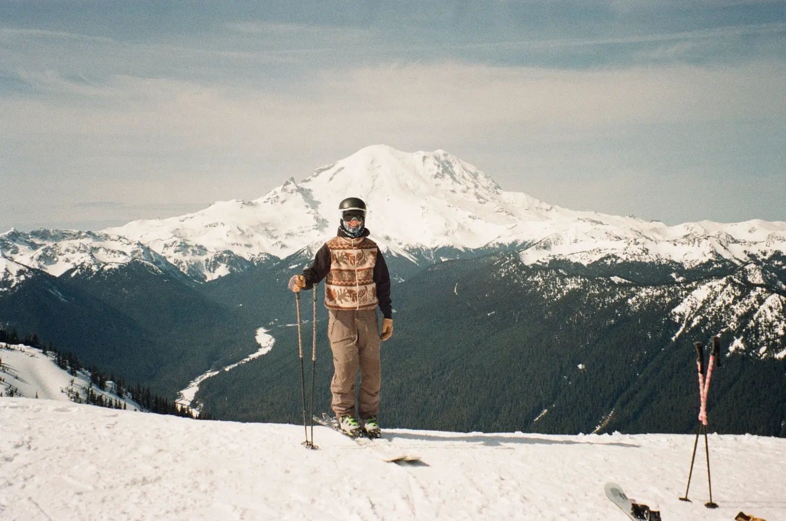 Skier posing in front of a broad snow-covered mountain