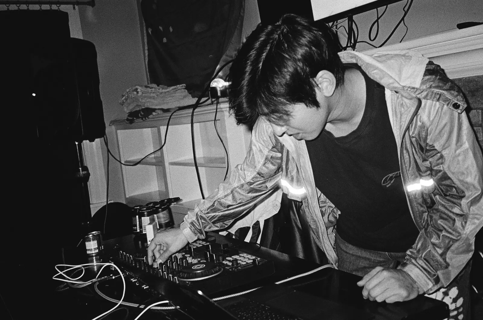 DJ adjusting a mixer in a dark room